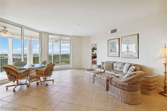 living room with ceiling fan, floor to ceiling windows, and light tile patterned flooring