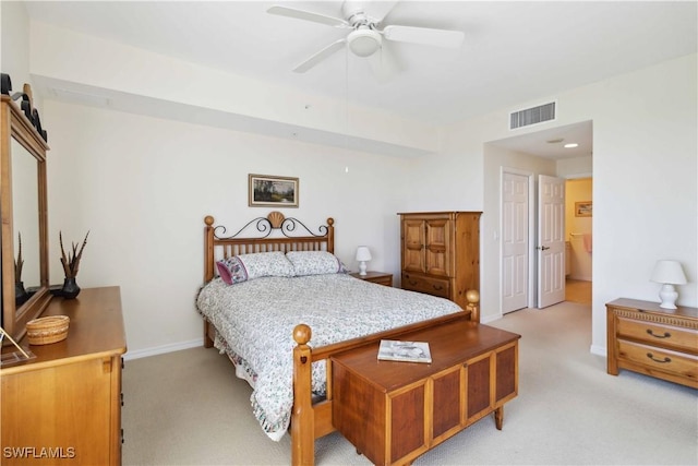 bedroom featuring ceiling fan, ensuite bathroom, and light carpet