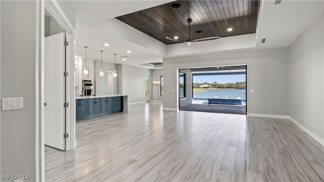 entrance foyer featuring ceiling fan, a raised ceiling, wooden ceiling, light hardwood / wood-style flooring, and a water view