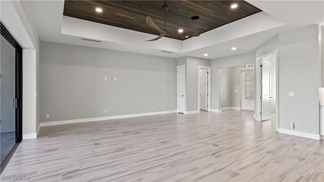 unfurnished room with light hardwood / wood-style floors and a tray ceiling