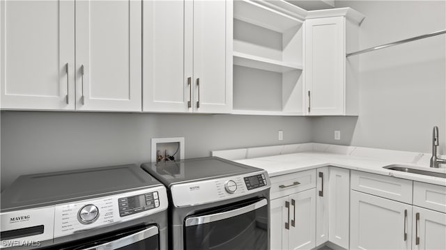 laundry room with cabinets, sink, and washing machine and dryer