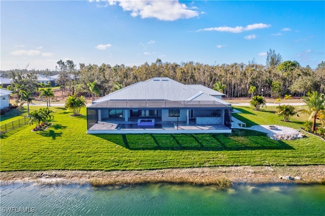 back of house with a water view, a patio, a lawn, and a swimming pool