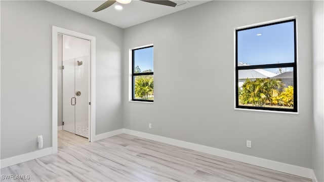 spare room with ceiling fan, light wood-type flooring, and a wealth of natural light