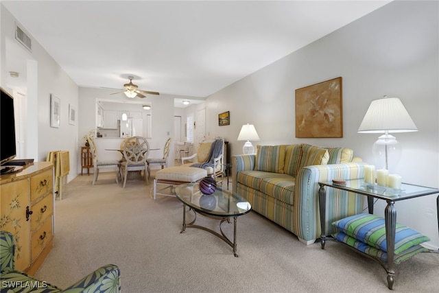 carpeted living room featuring ceiling fan