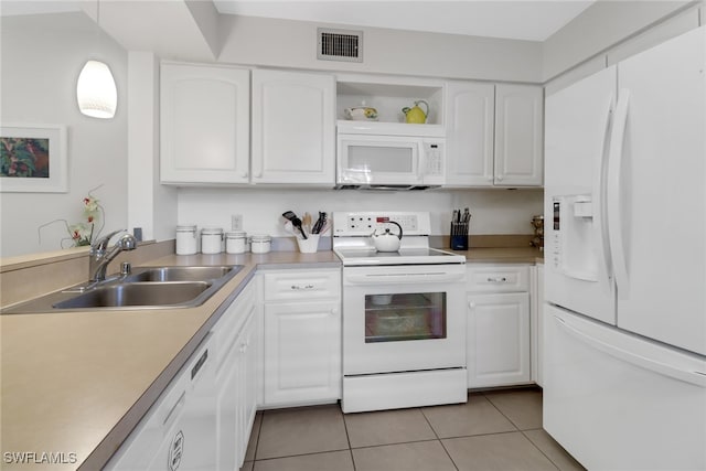 kitchen with white cabinets, sink, light tile patterned floors, and white appliances