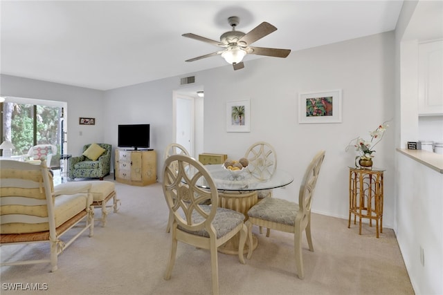 carpeted dining space featuring ceiling fan