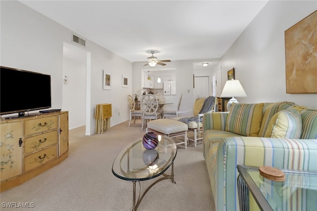 carpeted living room featuring ceiling fan