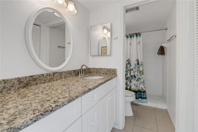 bathroom with toilet, a shower with curtain, vanity, and tile patterned floors