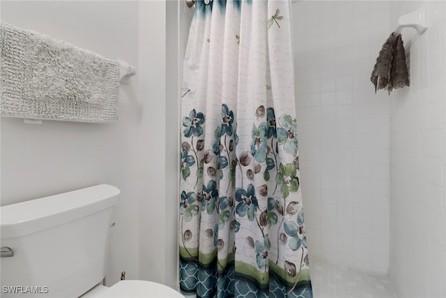 bathroom featuring a shower with curtain and toilet