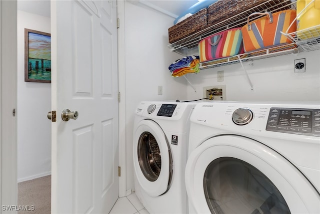 laundry area featuring washer and clothes dryer and light tile patterned floors