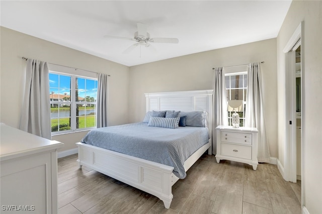 bedroom with ceiling fan and light hardwood / wood-style floors