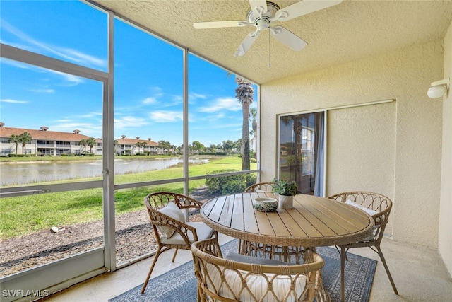 sunroom with a water view and ceiling fan