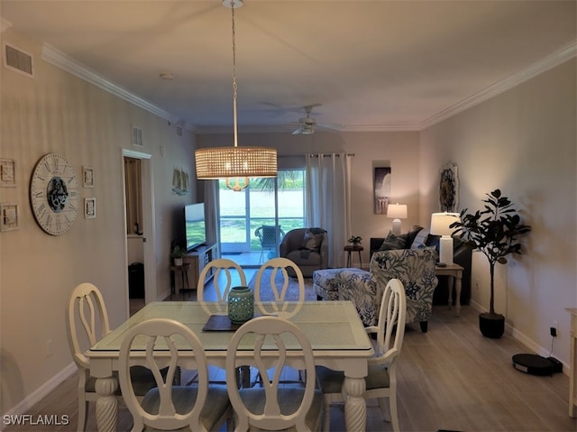 dining room featuring light hardwood / wood-style flooring, crown molding, and ceiling fan