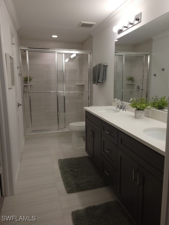 bathroom with toilet, an enclosed shower, vanity, and tile patterned flooring