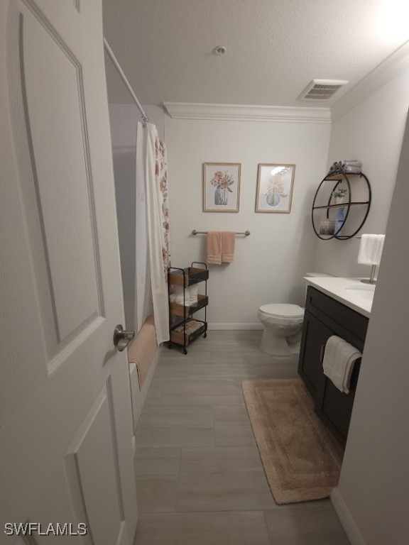 full bathroom with vanity, ornamental molding, toilet, and shower / bathtub combination with curtain