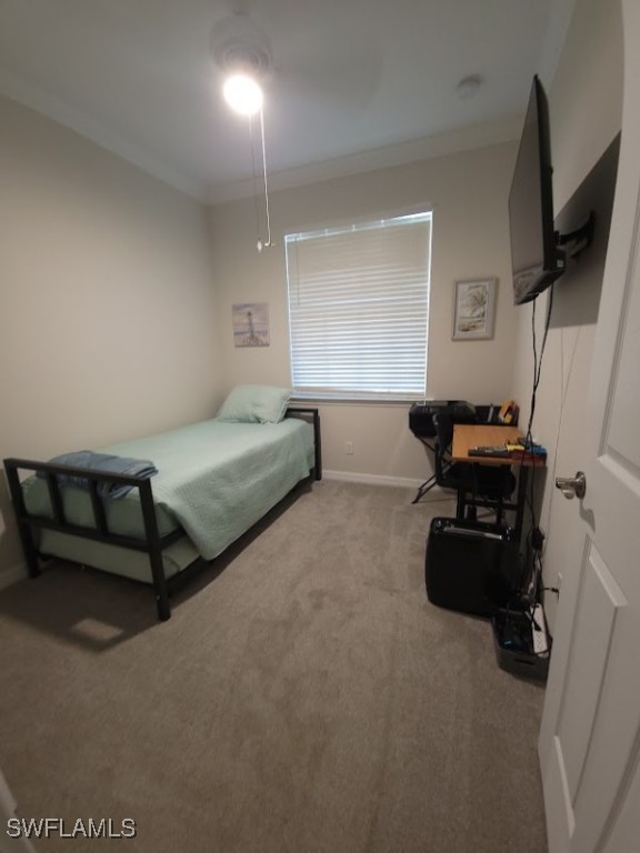 bedroom with ornamental molding and carpet floors