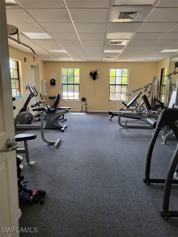 exercise room with a drop ceiling and plenty of natural light