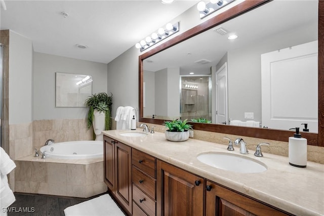 bathroom featuring double vanity, a sink, a bath, and a shower stall