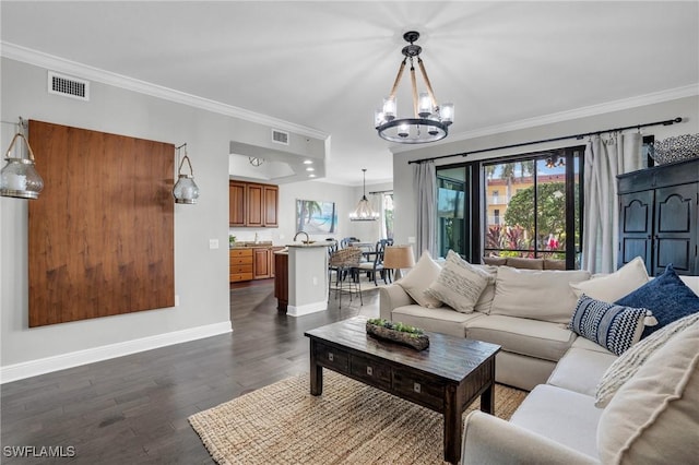 living room featuring a notable chandelier, sink, dark hardwood / wood-style floors, and ornamental molding