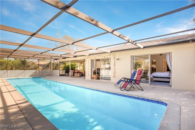 view of swimming pool with a patio area and glass enclosure