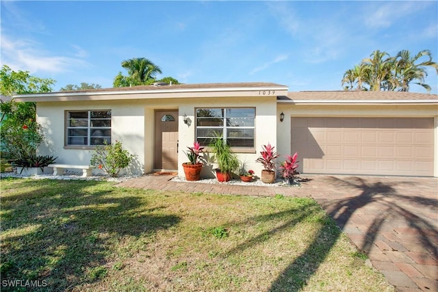 1039 Cardinal St, Naples, FL 34104 - ranch-style home with a garage, driveway, a front yard, and stucco siding