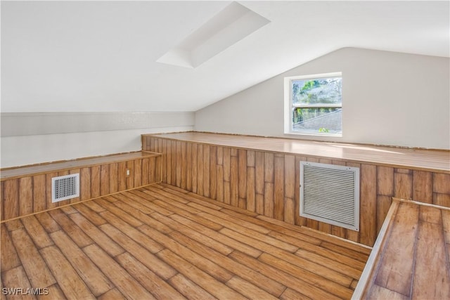 1039 Cardinal St, Naples, FL 34104 - additional living space with wooden walls, vaulted ceiling, visible vents, and hardwood / wood-style flooring