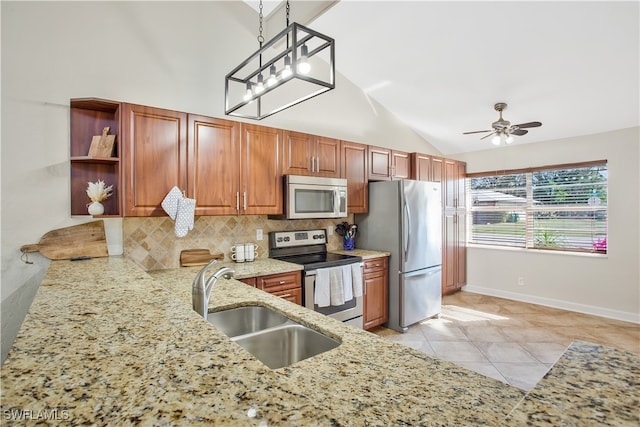 kitchen featuring appliances with stainless steel finishes, sink, backsplash, vaulted ceiling, and pendant lighting