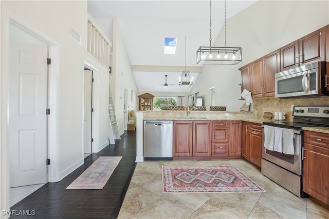 kitchen featuring kitchen peninsula, stainless steel appliances, pendant lighting, high vaulted ceiling, and light hardwood / wood-style floors