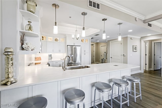 kitchen featuring crown molding, dark wood-type flooring, stainless steel fridge with ice dispenser, a peninsula, and a sink