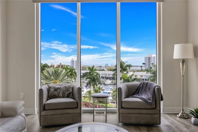 living room with a city view, wood finished floors, and baseboards