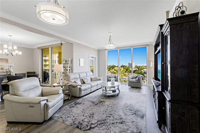 living area with crown molding, floor to ceiling windows, wood finished floors, and a chandelier