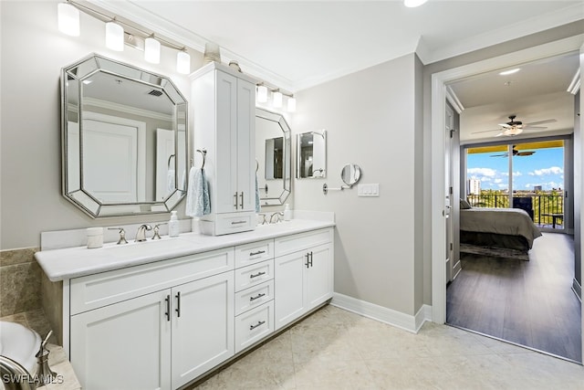 bathroom featuring ceiling fan, double vanity, ornamental molding, and a sink