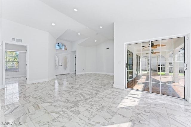 unfurnished living room featuring high vaulted ceiling and ceiling fan