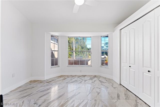 unfurnished bedroom with ceiling fan and a closet