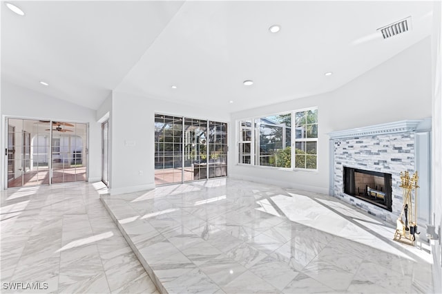 unfurnished living room featuring lofted ceiling and a tile fireplace