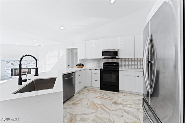 kitchen featuring white cabinetry, sink, kitchen peninsula, appliances with stainless steel finishes, and lofted ceiling