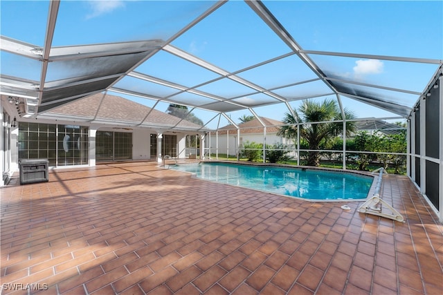 view of swimming pool with glass enclosure and a patio