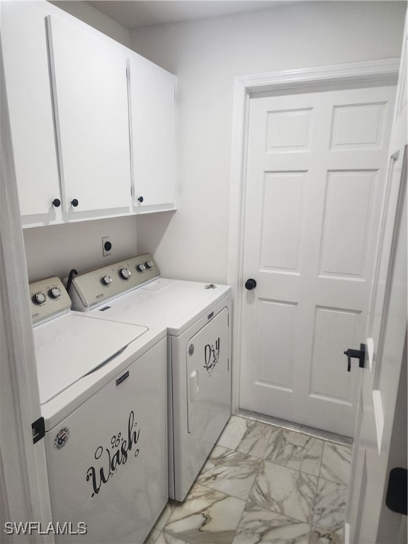 laundry area with separate washer and dryer and cabinets