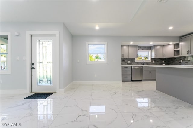 kitchen with decorative backsplash, stainless steel dishwasher, gray cabinetry, and sink