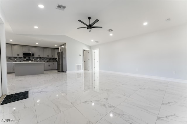 unfurnished living room featuring ceiling fan and lofted ceiling