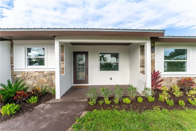 view of exterior entry featuring covered porch