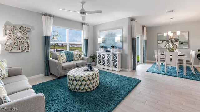 living room with light hardwood / wood-style flooring and ceiling fan with notable chandelier