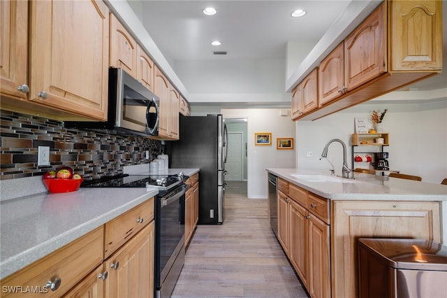 kitchen with decorative backsplash, light brown cabinetry, light hardwood / wood-style flooring, sink, and stainless steel appliances