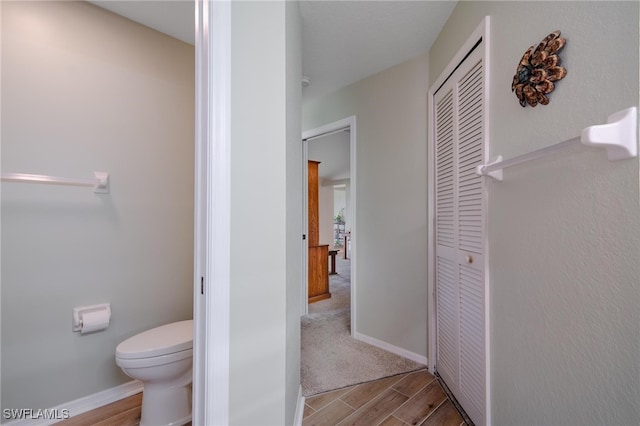 bathroom with toilet and hardwood / wood-style flooring