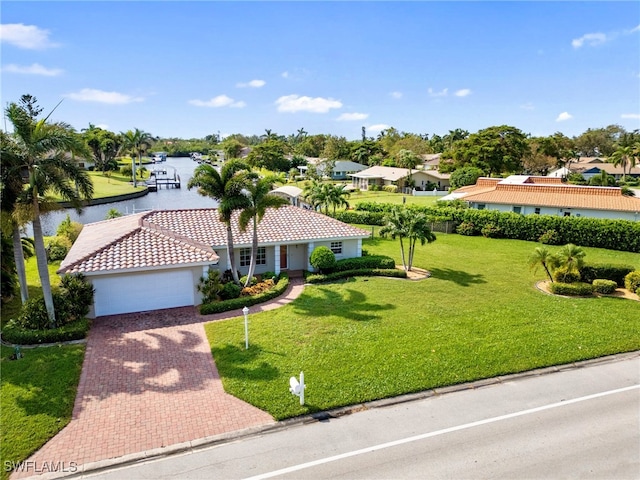 view of front of house featuring a front yard, a garage, and a water view