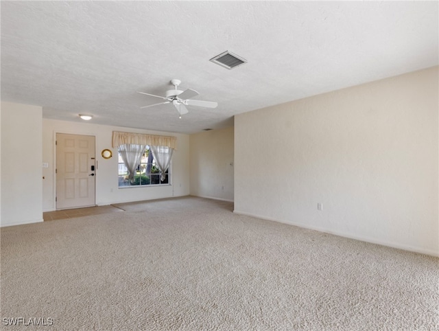 carpeted empty room with a textured ceiling and ceiling fan