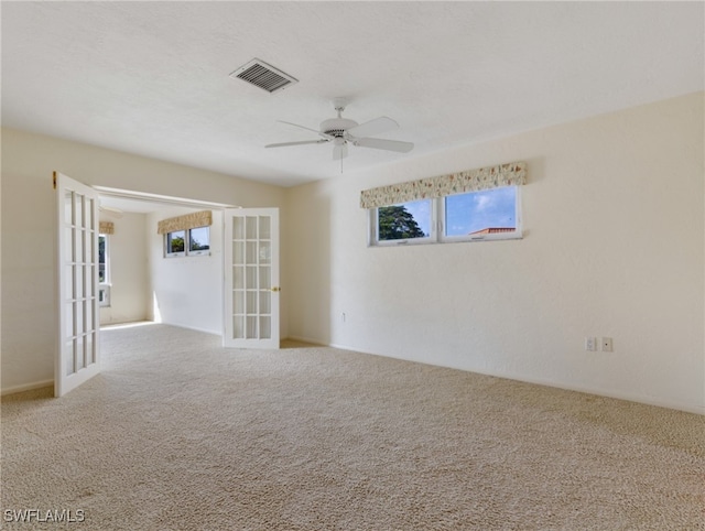 carpeted spare room with french doors and ceiling fan