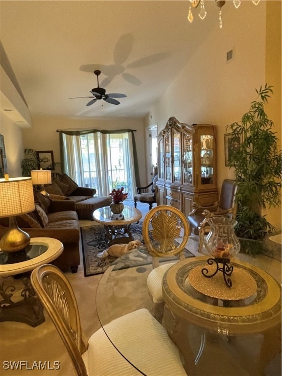 carpeted living room featuring ceiling fan with notable chandelier