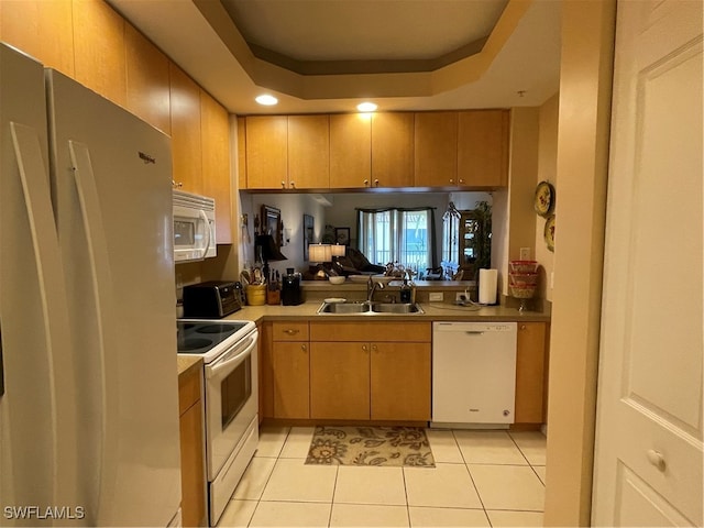 kitchen featuring light tile patterned flooring, sink, a raised ceiling, and white appliances