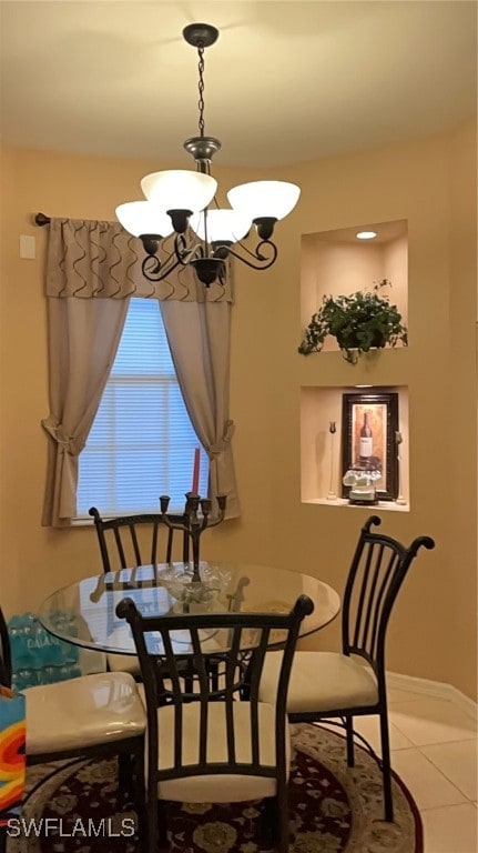 tiled dining room with an inviting chandelier